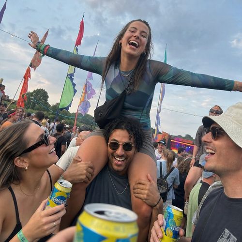 Bright photo of a friend riding on shoulders above a festival crowd
